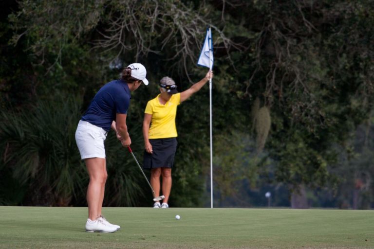 golfeuse entrain de réaliser un putt