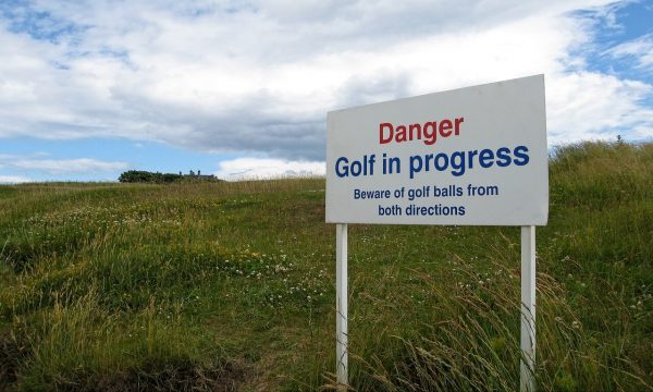 Panneau prévenant d'un danger à l'entrée d'un parcours de golf.